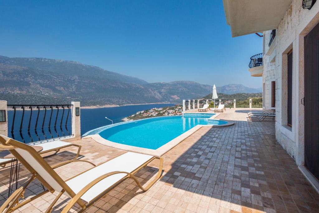 a swimming pool with chairs and a view of the water at Hillcity Hotel in Kas