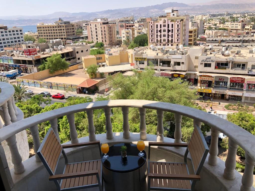 a balcony with chairs and a view of a city at Dweik Hotel 2 in Aqaba