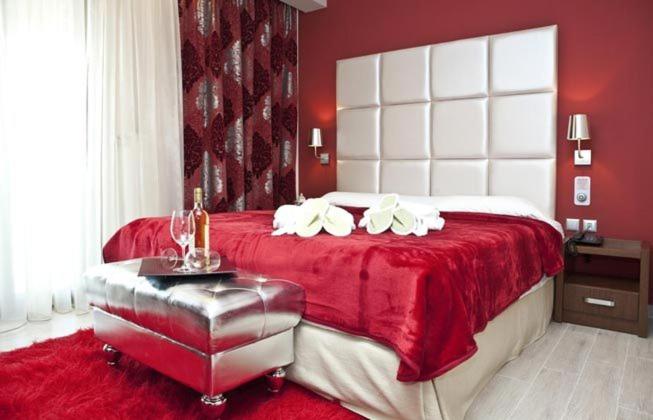a red bedroom with a large bed with a red blanket at Hotel Konaki in Arnaia