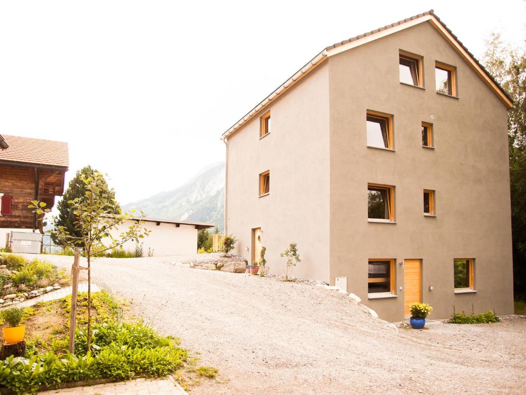 ein Haus an der Seite einer unbefestigten Straße in der Unterkunft Nangijala Guest House in Disentis