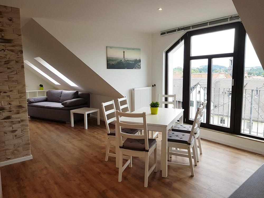 sala de estar con mesa, sillas y sofá en Ferienwohnung Schlosswächter am Schloss Colditz, en Colditz