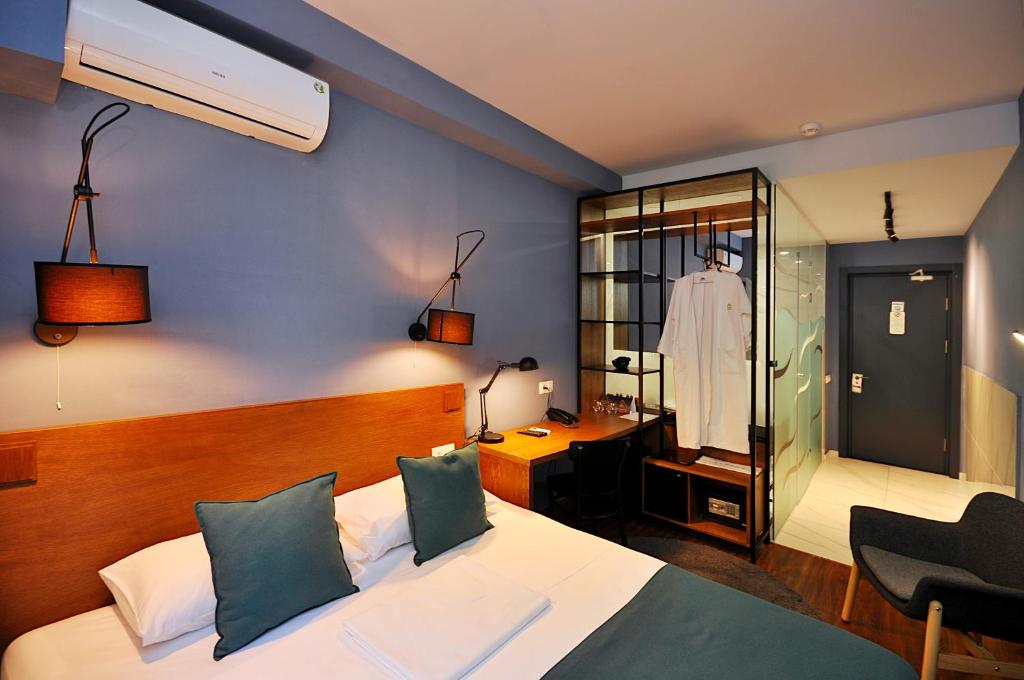 - une chambre avec un lit, un bureau et un miroir dans l'établissement Elle Boutique Hotel, à Tbilissi