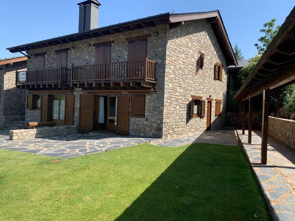 un gran edificio de ladrillo con balcón y patio en Can Marc de Pi, Bellver de Cerdanya, en Pi