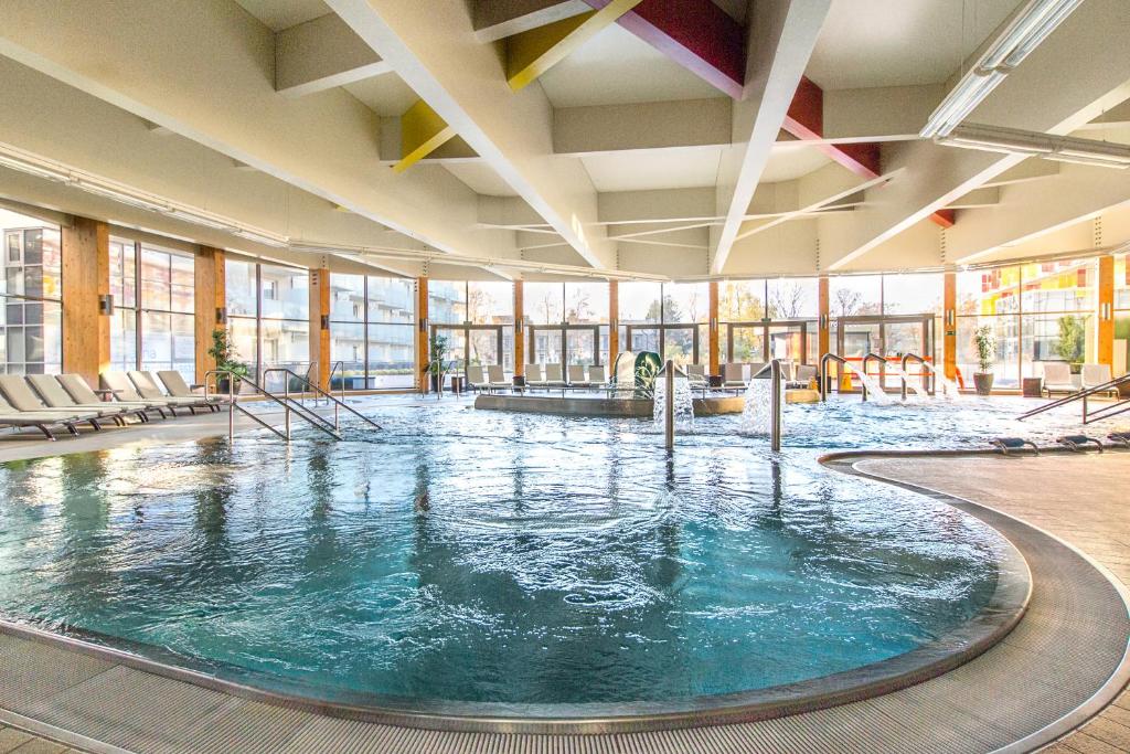 a large swimming pool in a large room with windows at Hotel Aquarius SPA in Kołobrzeg