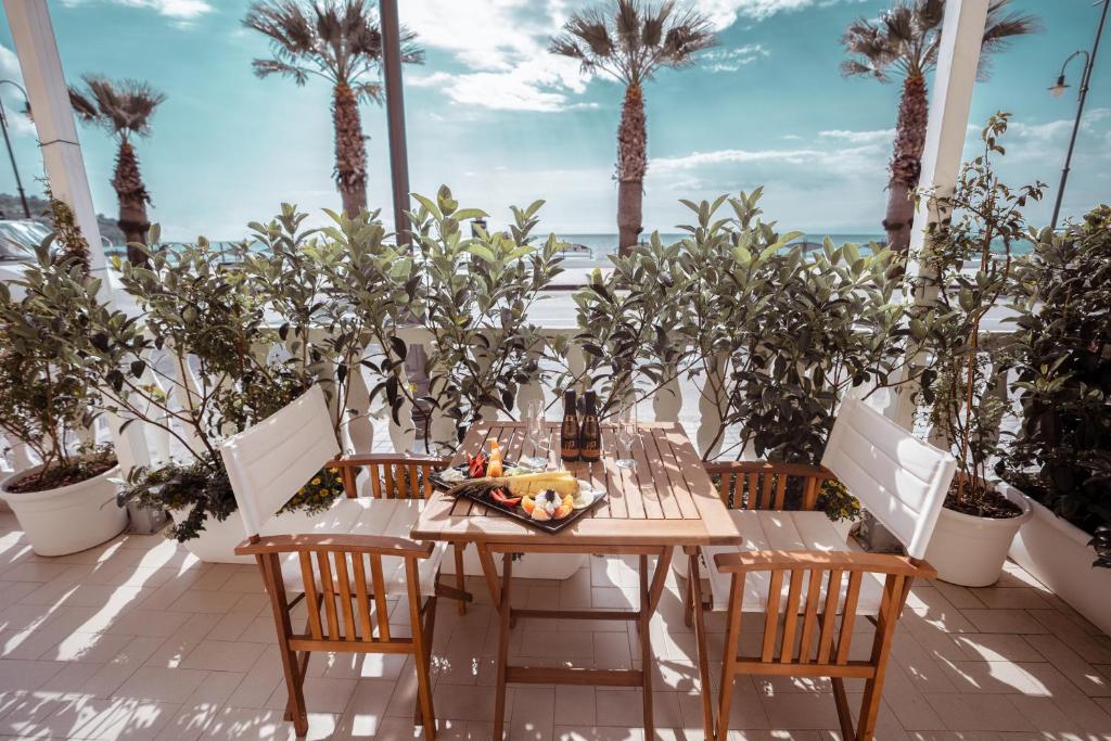 stół i krzesła na patio z palmami w obiekcie Break for two w Agropoli