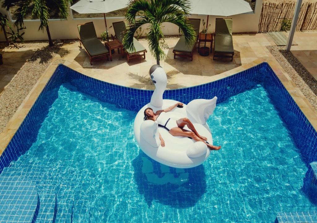 a woman riding on a swan in a swimming pool at White Wind Resort in Itarema