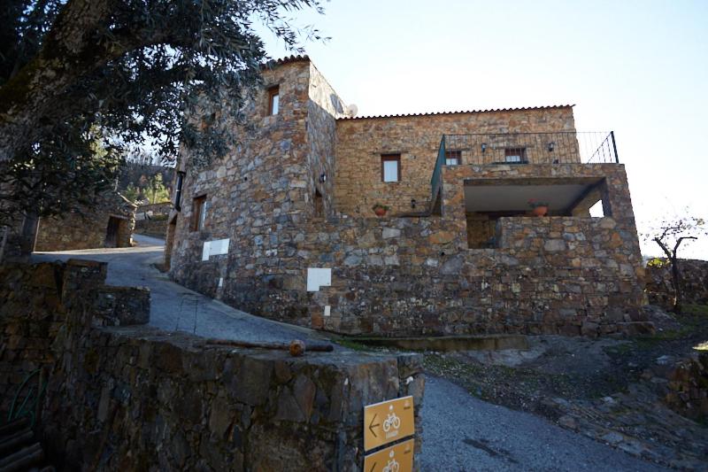 a large stone building with a stone wall at Casa da Eira - Água Formosa _ Vila de Rei in Vila de Rei