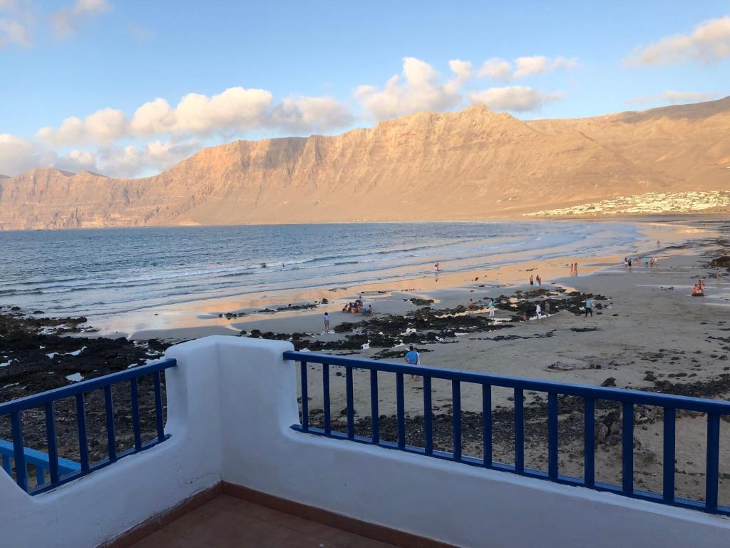 vistas a una playa con montañas en el fondo en Playa de Caleta de Famara, en Famara