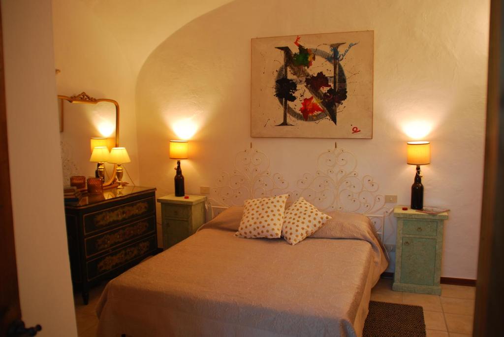 a bedroom with a bed with two night stands and two lamps at Orto di Emma in San Gimignano