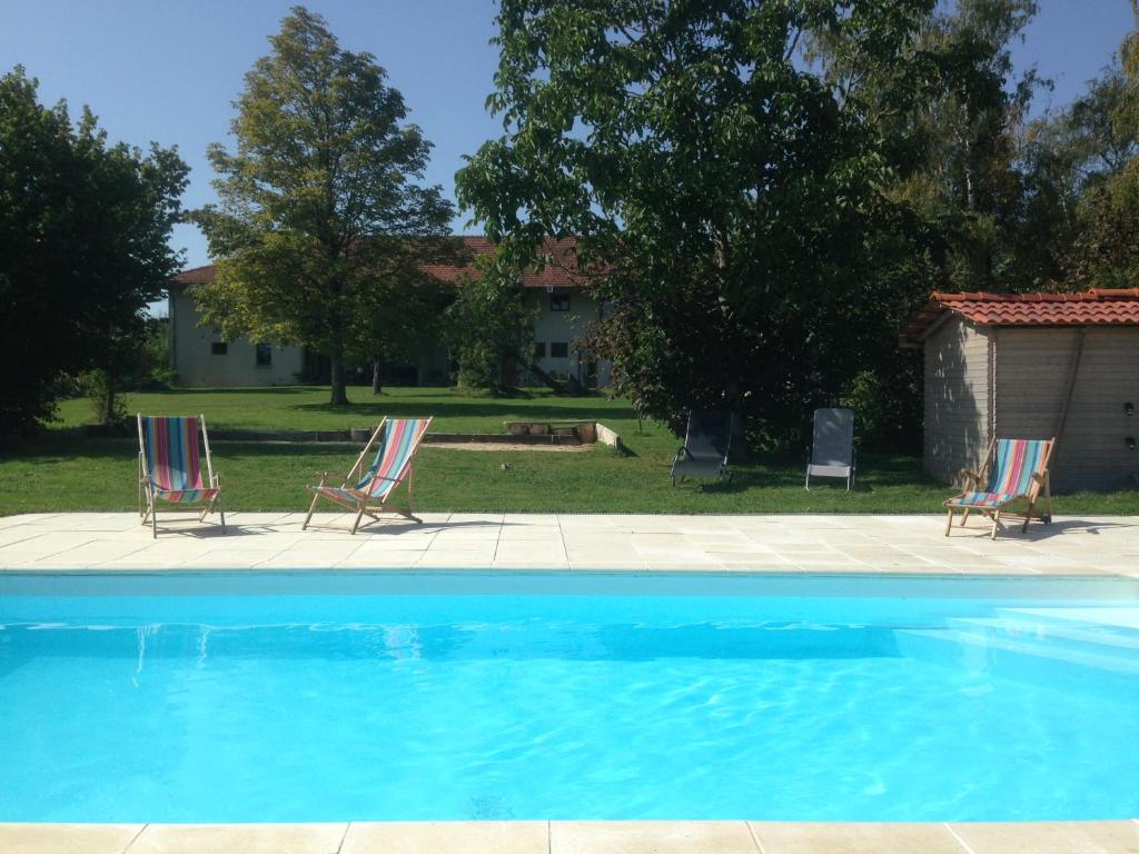 two chairs and a swimming pool in a yard at Verveine Patchouli in Saint-Martin-le-Châtel