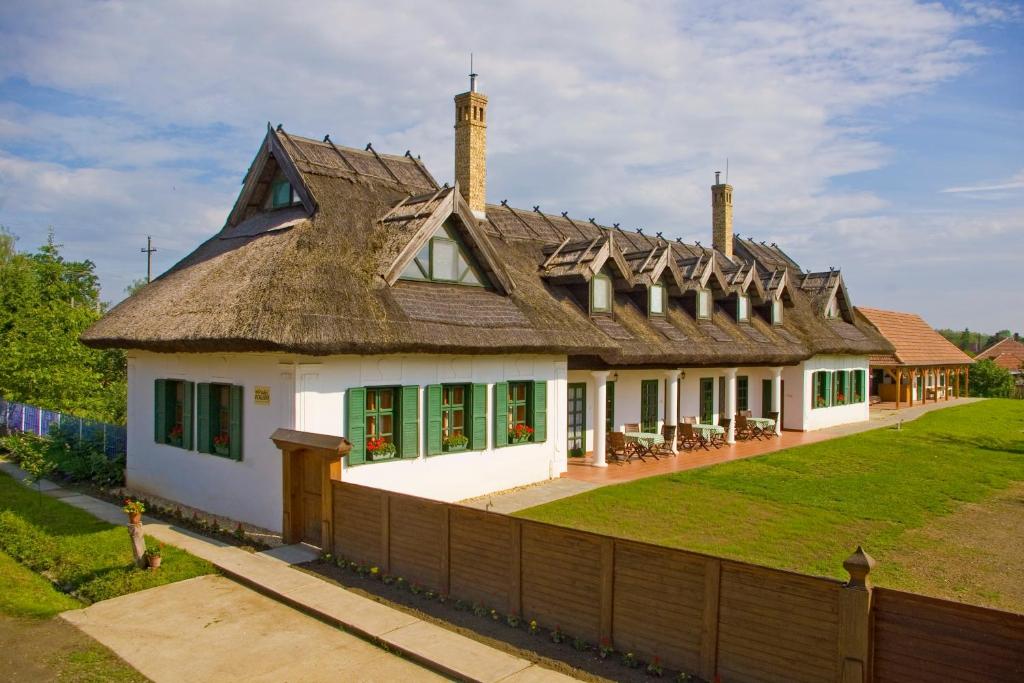 a large white house with a thatched roof at Nádas Fogadó in Tiszadob