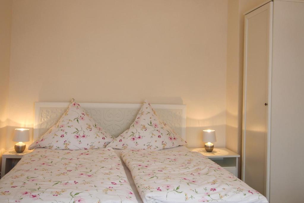 Bett mit rosa und weißer Bettwäsche und Kissen in der Unterkunft Ferienwohnung Zum Lilienstein in Bad Schandau