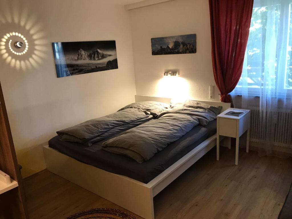 ein Schlafzimmer mit einem Bett mit einer Lampe und einem Fenster in der Unterkunft Apartment Kleissl in Sankt Anton am Arlberg
