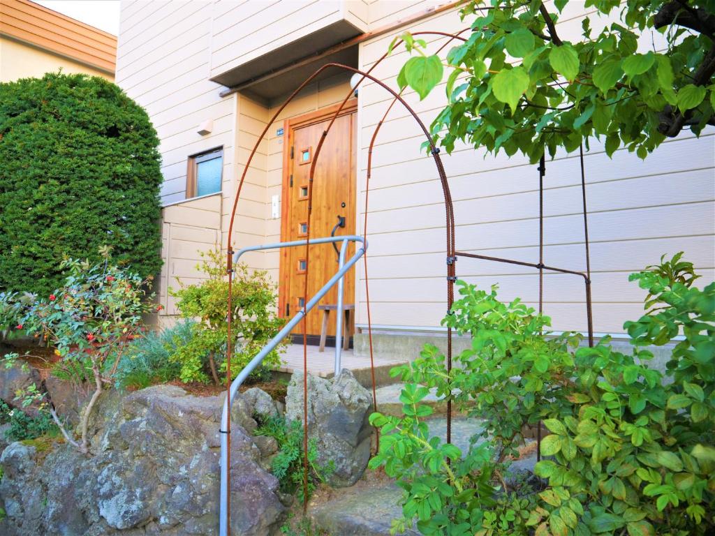 un giardino con altalena di fronte a una casa di Minpaku Mon a Sapporo