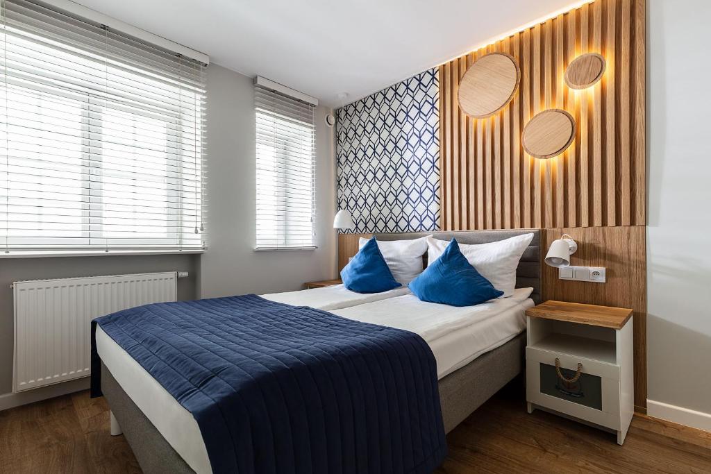 a bedroom with a large bed with blue pillows at Anchor House Sopot in Sopot