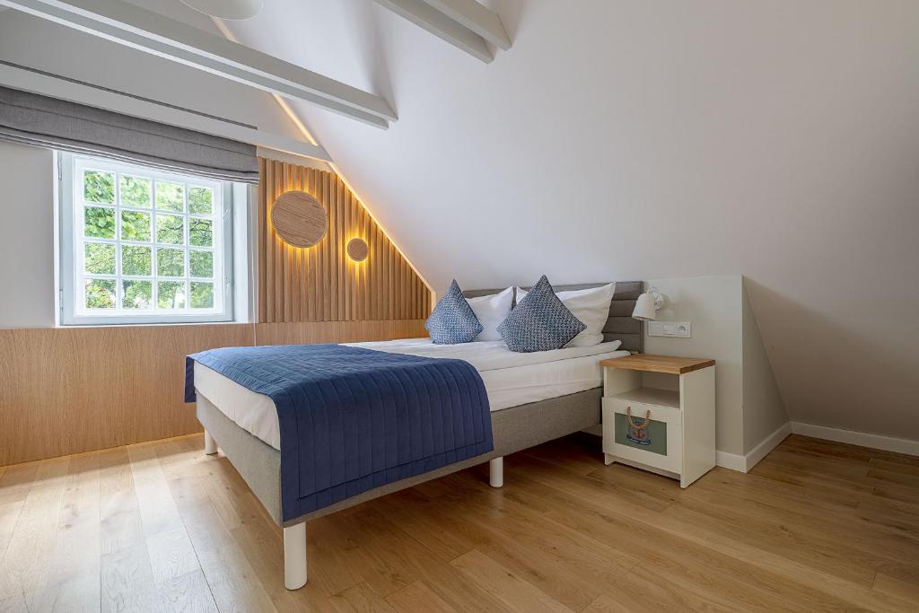 a bedroom with a bed with blue sheets and a window at Anchor House Sopot in Sopot