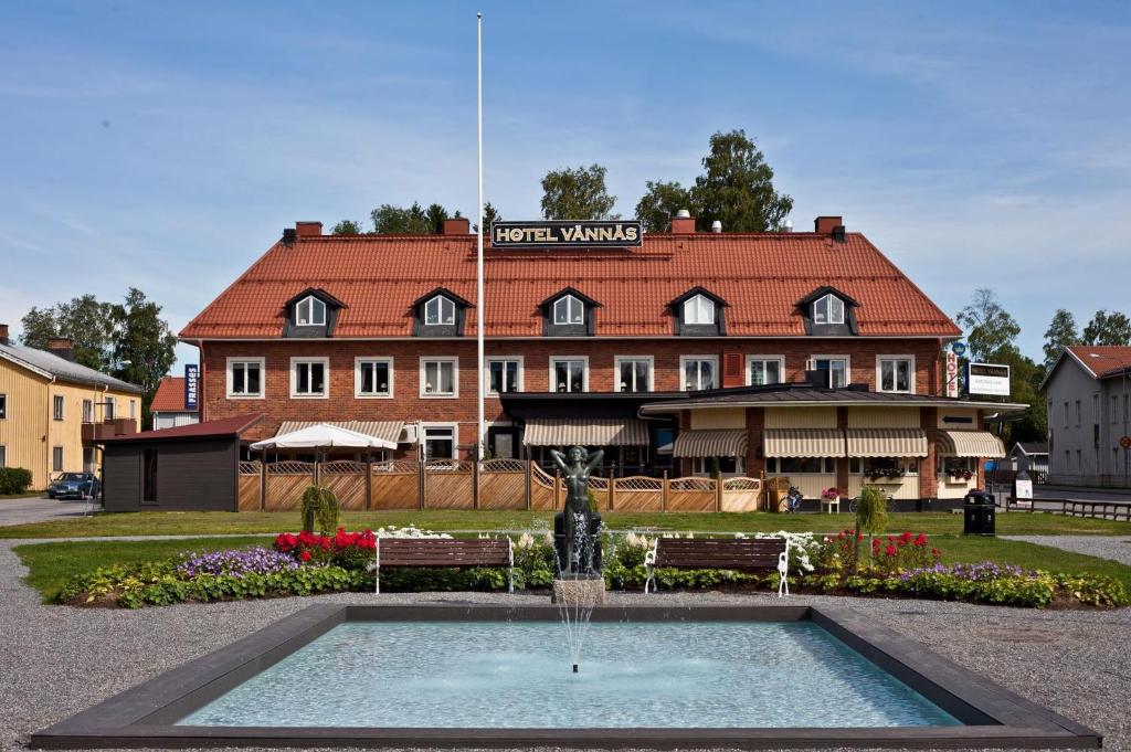 een hotel met een fontein voor een gebouw bij Hotel Vännäs in Vännäs