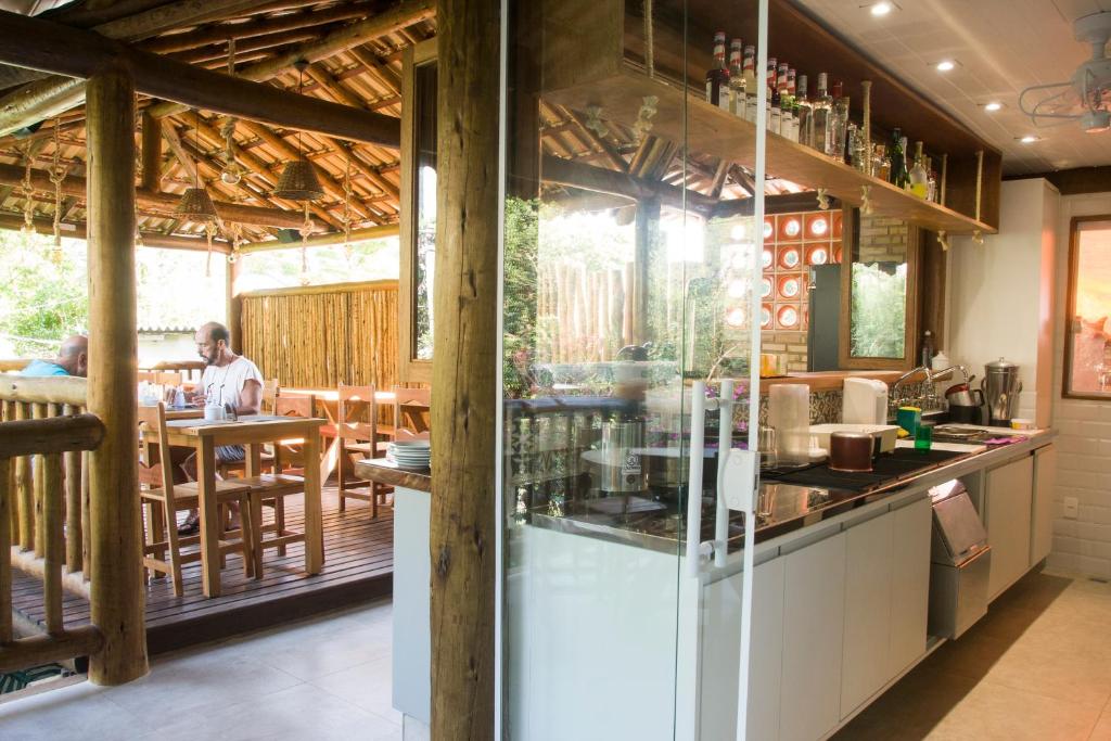 a restaurant with a counter and people sitting at a table at Pousada Albatroz in Abraão