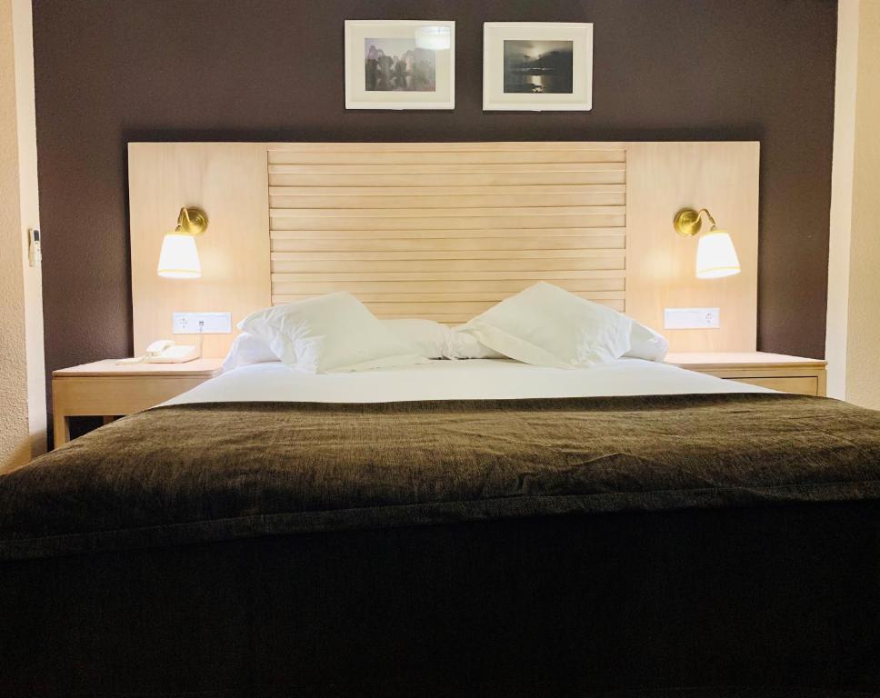 a bedroom with a large bed with two lights on it at Arriadh in Córdoba
