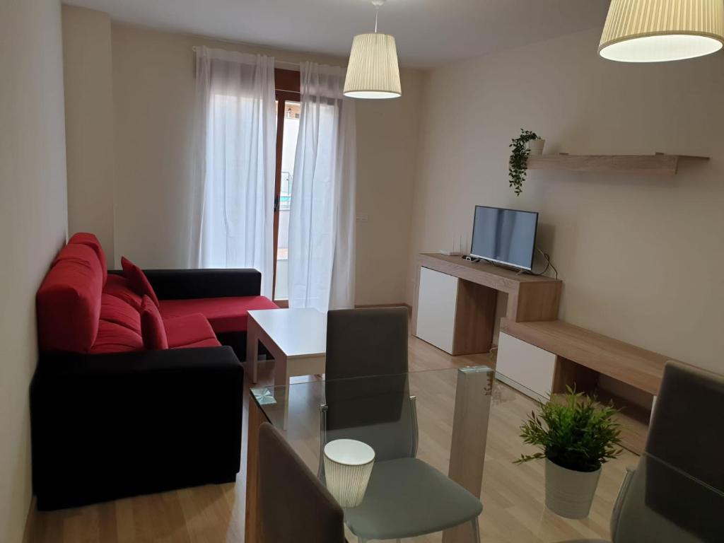 薩拉曼卡的住宿－Apartamento Turistico Puente Romano P3 BAJO - B，客厅配有红色沙发和电视