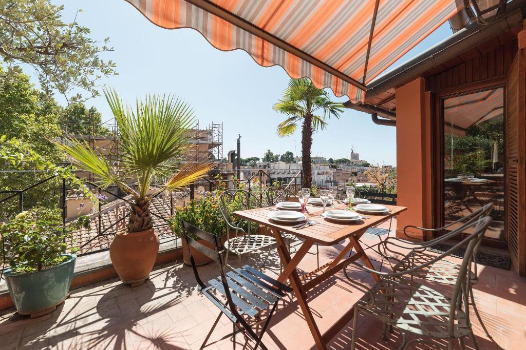 a patio with a table and chairs on a balcony at The Spanish Steps Grand Penthouse in Rome