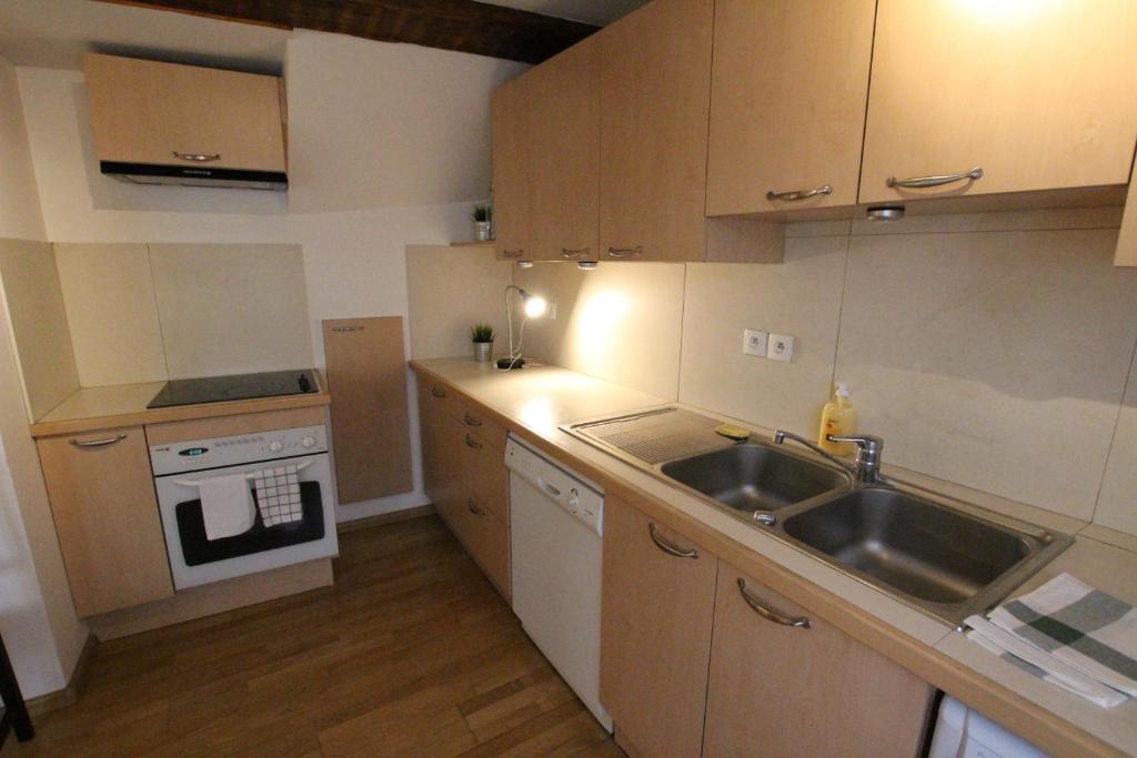 une petite cuisine avec un évier et une cuisinière dans l'établissement Colmar Historic Center - Alsacian Appartement PETITE VENISE 2 - BookingAlsace, à Colmar