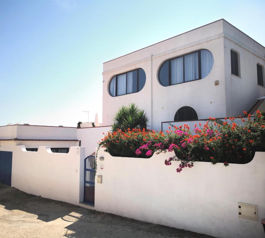 a white house with flowers on the side of it at B&B Villa Ziella in Portopalo