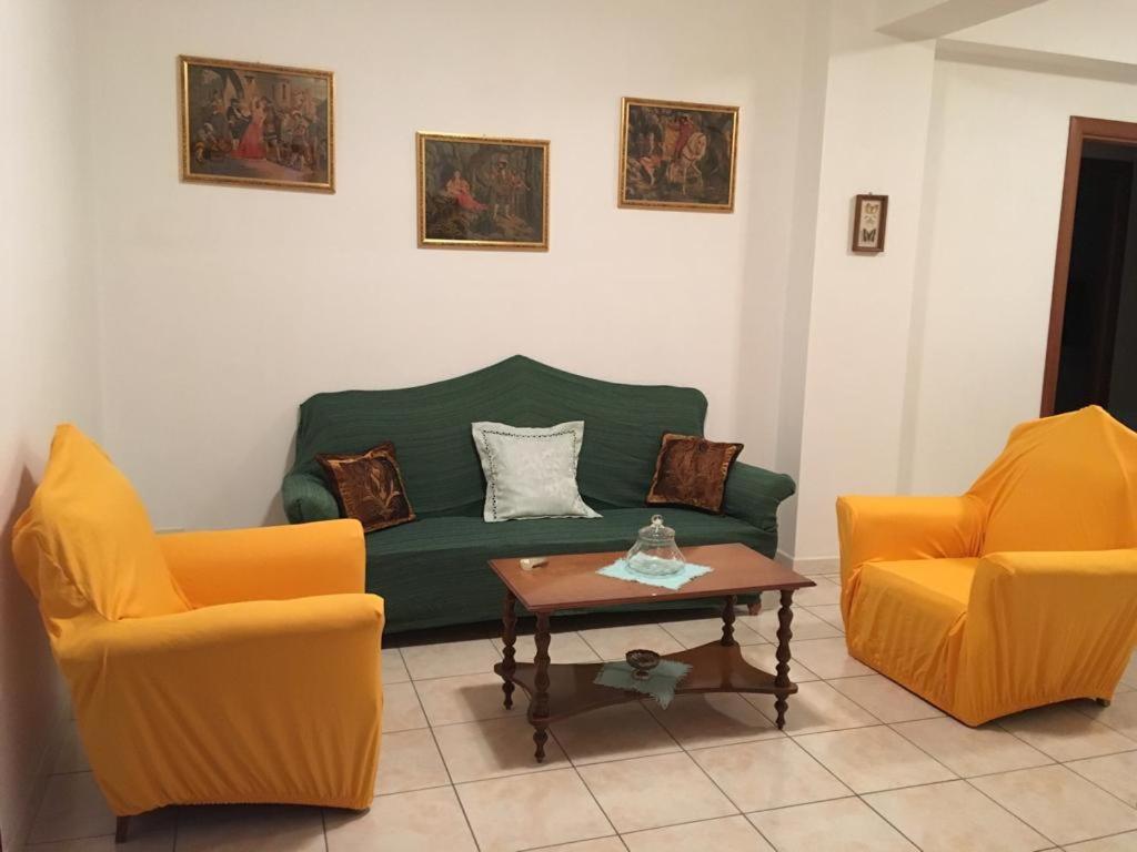 een woonkamer met een groene bank en 2 oranje stoelen bij Appartamento Gurrieri in Modica