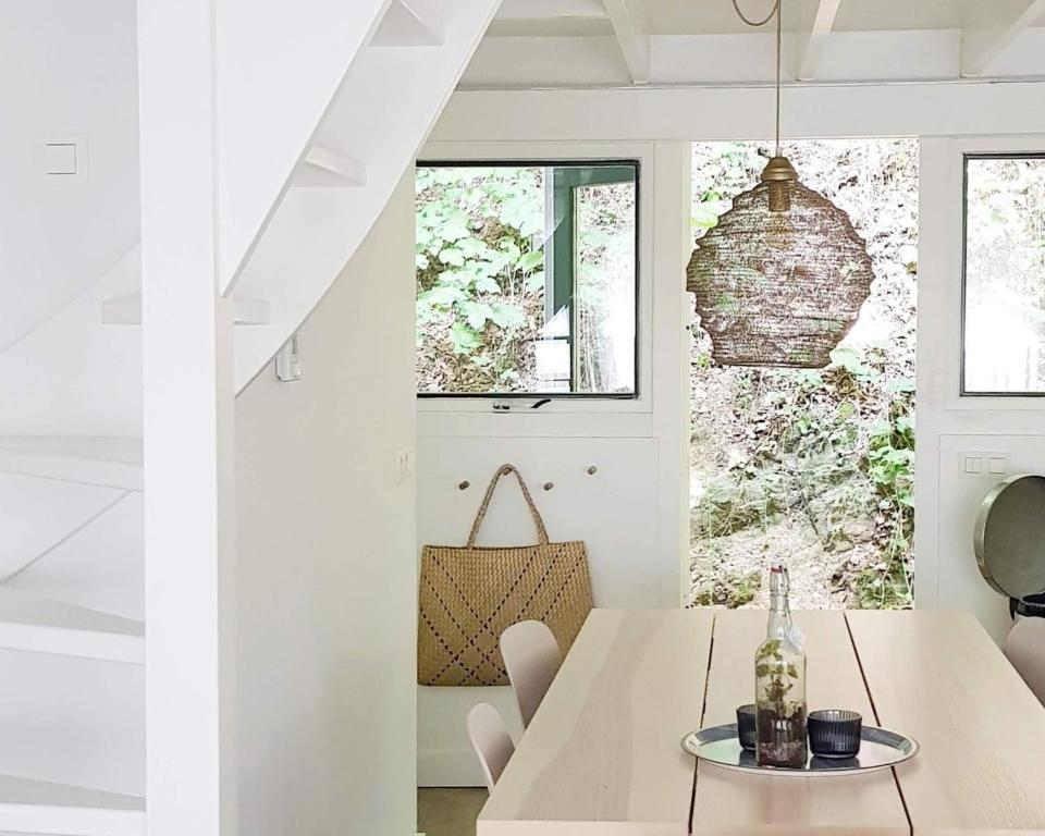 a white dining room with a table and chairs at Modern A-Frame vakantiehuis Durbuy Ardennen in Durbuy