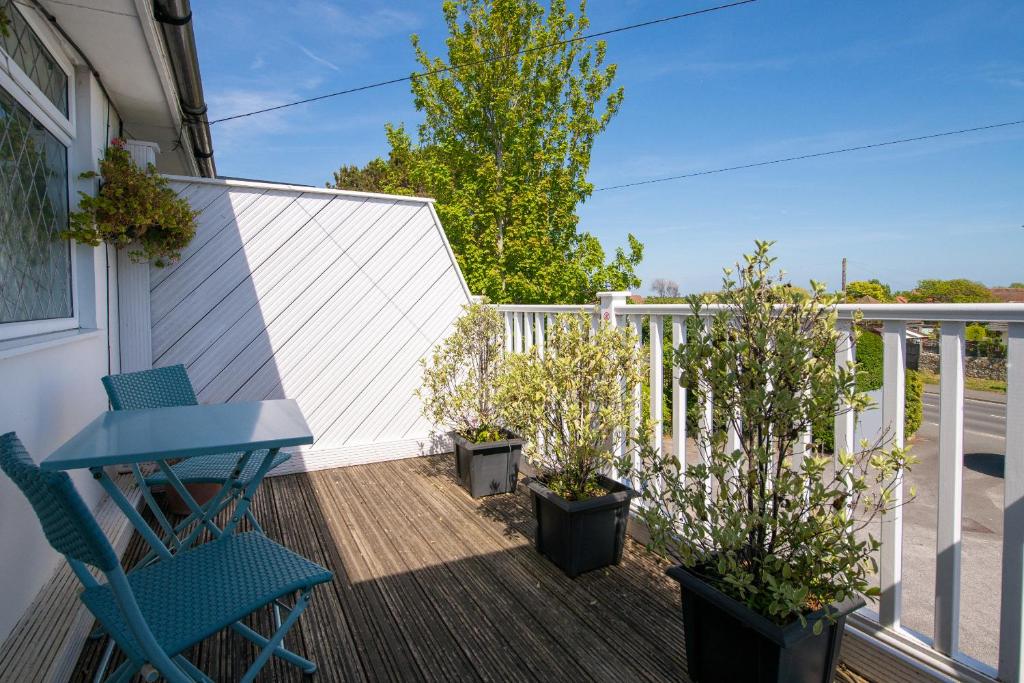 a patio with two chairs and a table on a deck at The Coast Yard B & B and Garden Chalets in Selsey