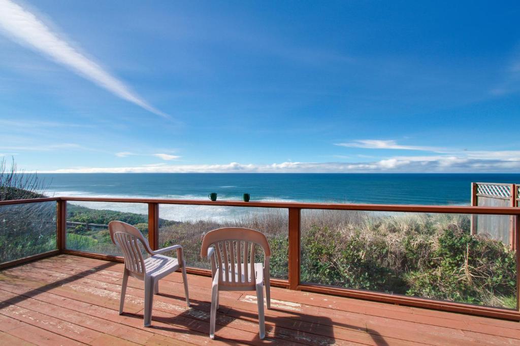 two chairs on a deck with a view of the ocean at Pirate's Paradise in Lincoln City