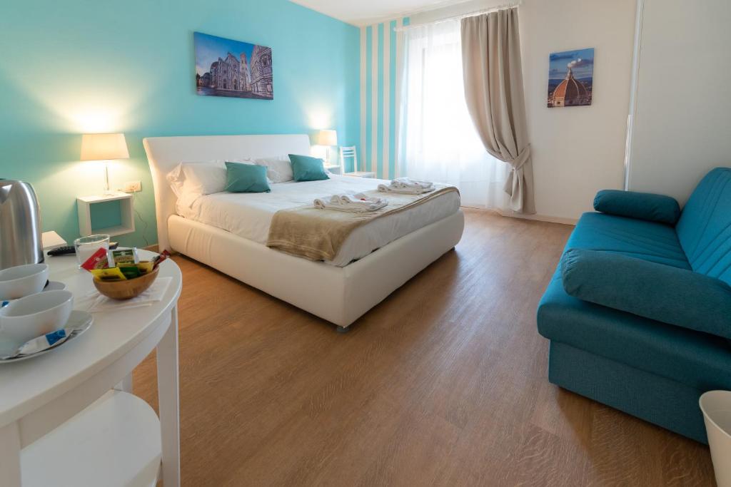 um quarto com uma cama branca e um sofá azul em FLOREST Guest House em Florença