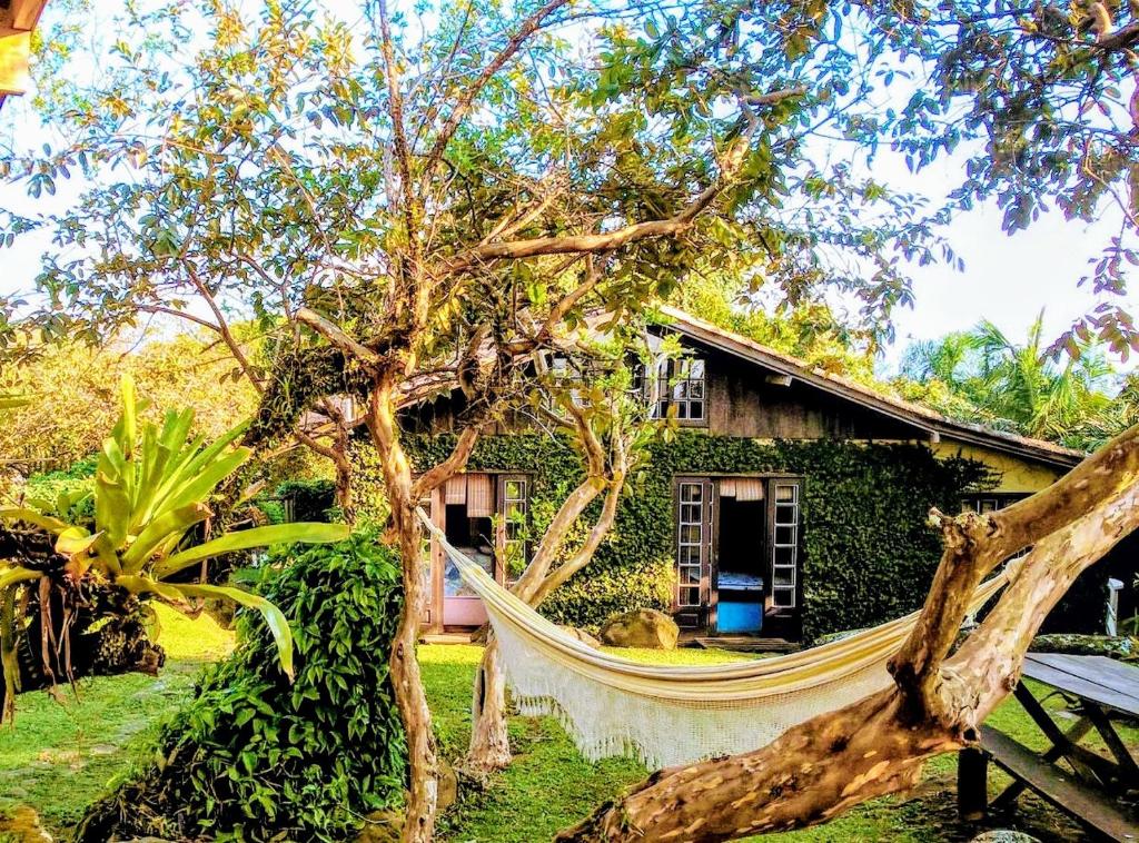a hammock in front of a house at Casa na Praia do Rosa in Praia do Rosa