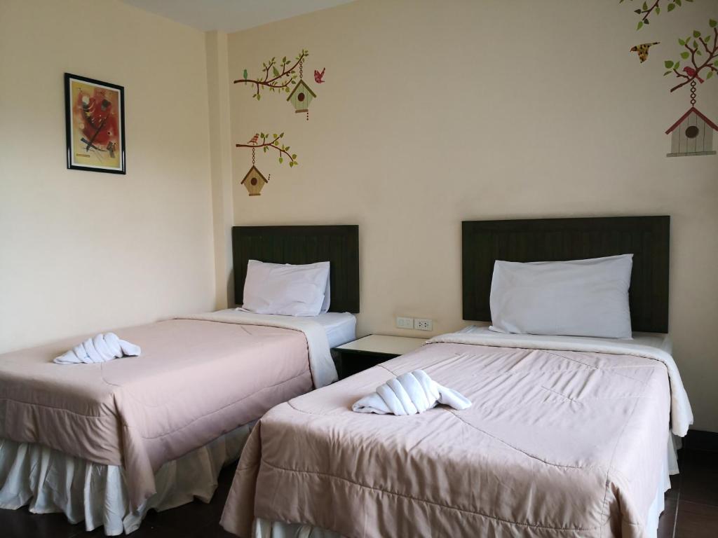 Postel nebo postele na pokoji v ubytování Baan Suksiri Hotel