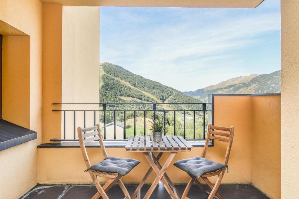 2 sillas y mesa en un balcón con vistas en Apartamento Fontargent, en Soldeu