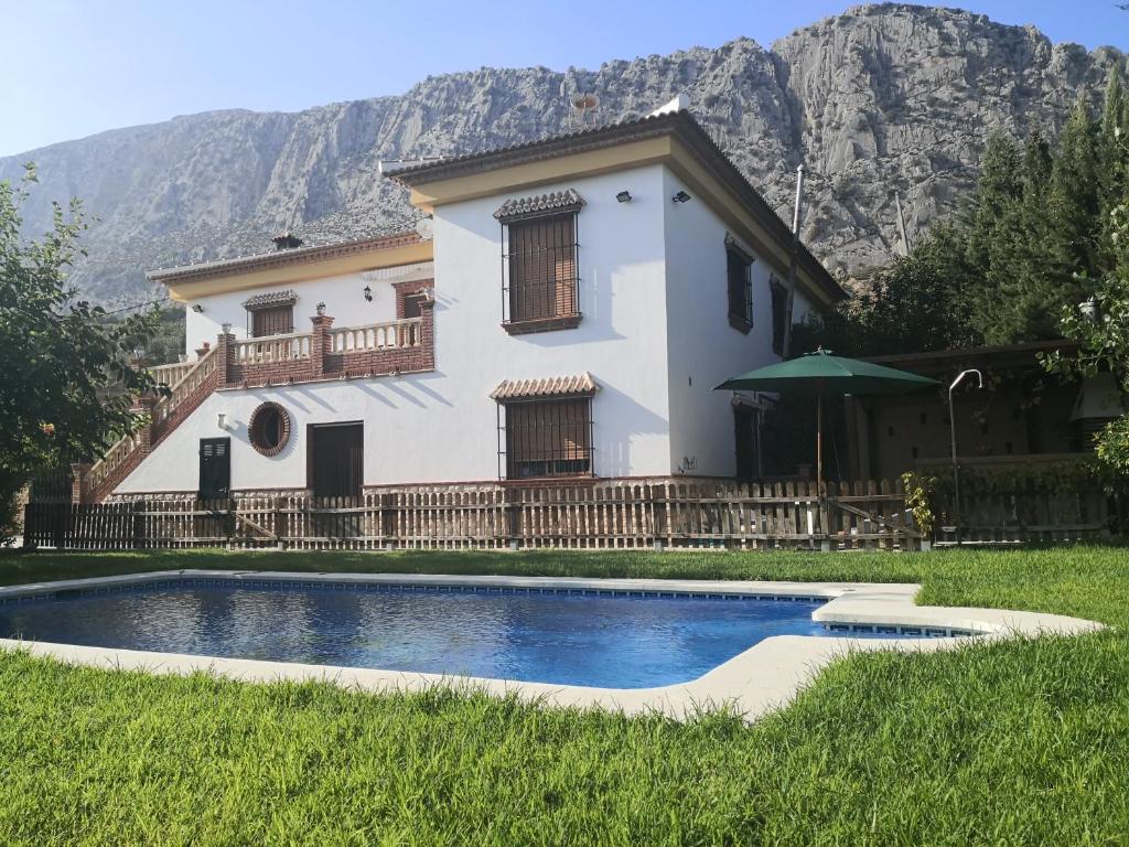 uma casa com piscina em frente a uma montanha em Villa Hierbabuena em Valle de Abdalagís