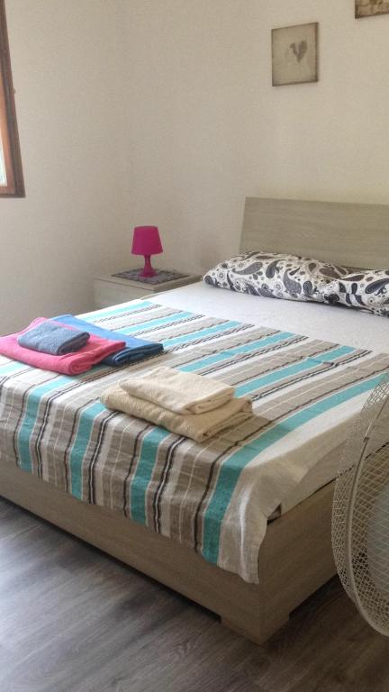 un letto con una coperta in una camera da letto di Casa Do Sol Apartment a Peschiera del Garda