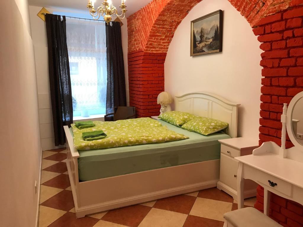 a bedroom with a bed in a room with a brick wall at Viktoria in Vienna