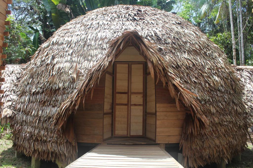 eine Hütte mit einem Strohdach und einer Tür in der Unterkunft Palmayacu - Refugio Amazónico in Leticia