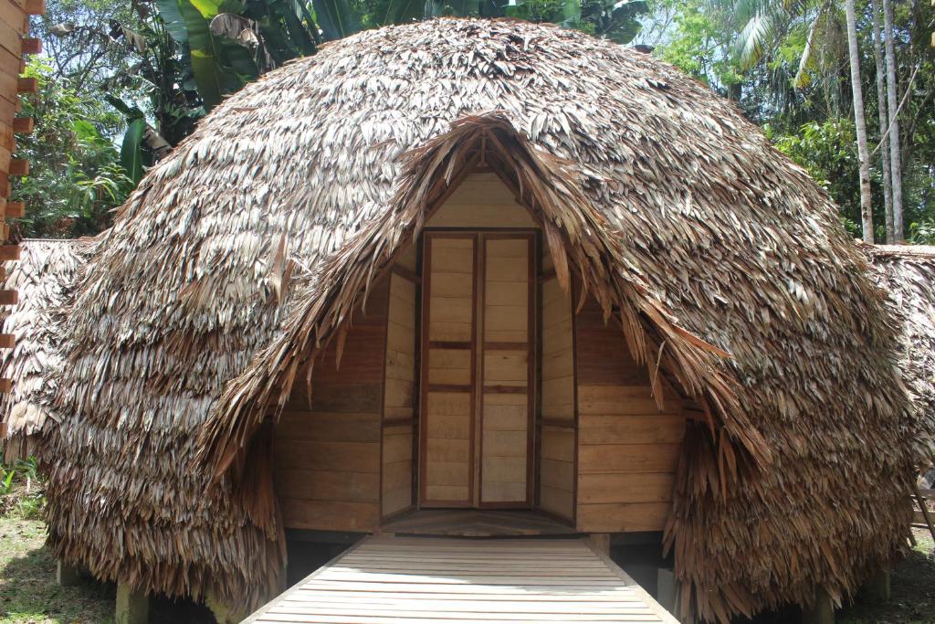 una capanna con tetto di paglia e porta di Palmayacu - Refugio Amazónico a Leticia