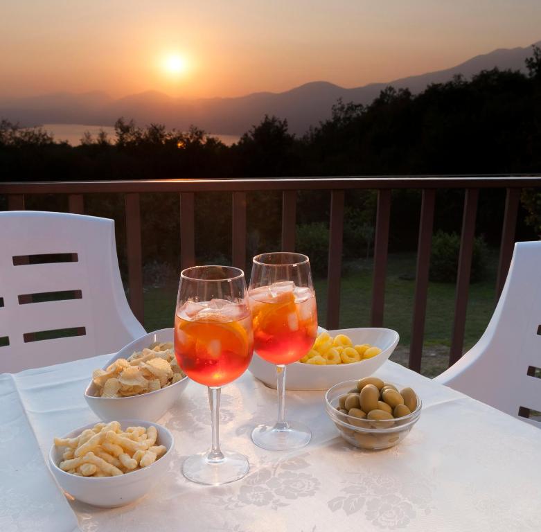 a table with two glasses of wine and bowls of food at Casa Fellini in San Zeno di Montagna