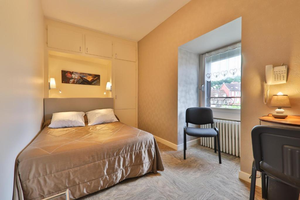 a bedroom with a bed and a chair and a window at Hôtel Bar Des Vosges in Munster