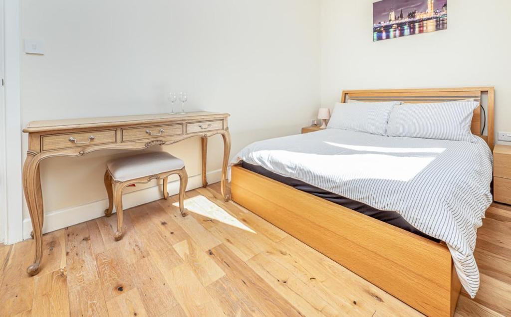 a bedroom with a wooden bed and a desk at easyStay Slough Central Apartment in Slough