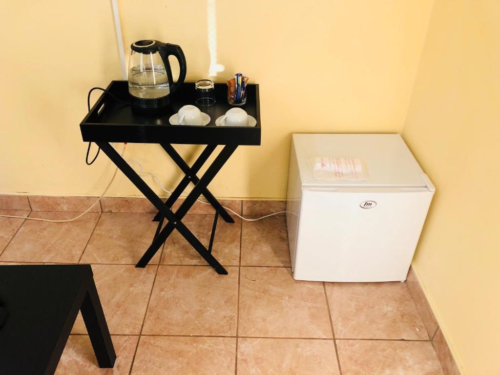 a small black table with a blender and a small refrigerator at Maite Villa Lodge in Thohoyandou