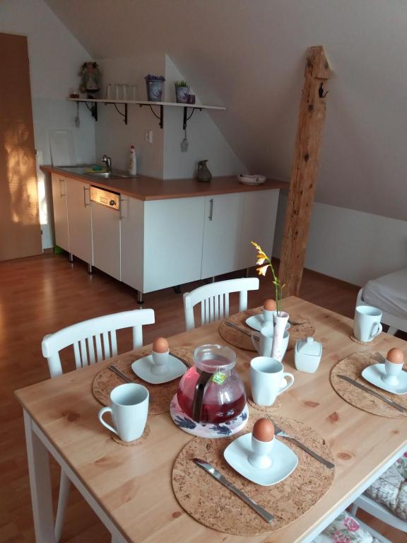 - une table en bois avec des assiettes et des tasses dans la cuisine dans l'établissement Apartmány F-M, à Frýdek-Místek