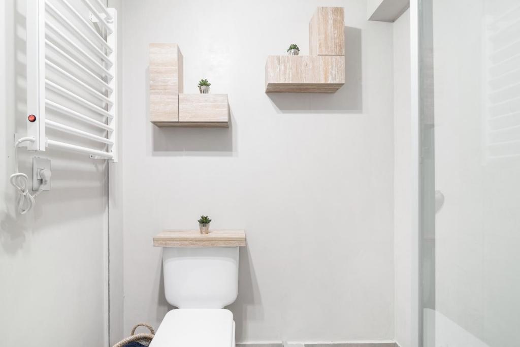 baño con aseo y 2 estanterías en la pared en Montañeses 2888 Flat, en Buenos Aires
