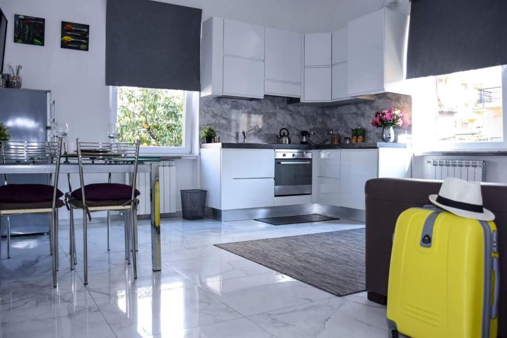 ローマにあるRampa Brancaleone Apartmentのキッチン(白いキャビネット、黄色のスーツケース付)