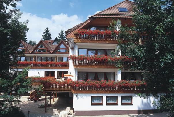 un bâtiment avec des fleurs sur ses balcons dans l'établissement Hotel Sonnenhof, à Bad Sachsa