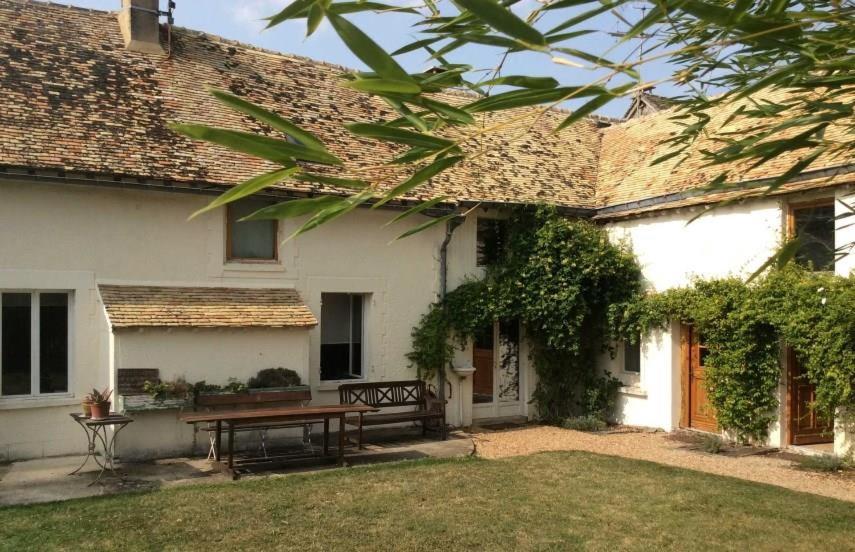 una casa con una mesa y un banco en el patio en Lilac cottage, en La Haye