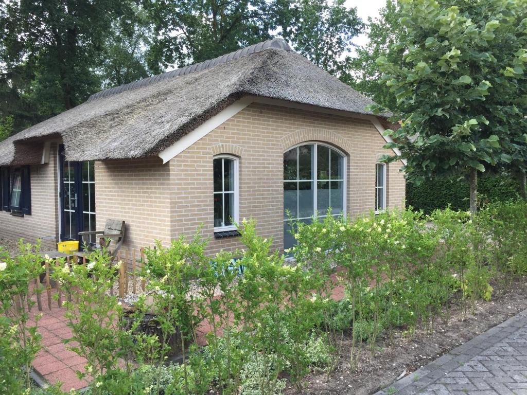 een klein bakstenen huis met een grasdak bij RiemersHof in Ermelo